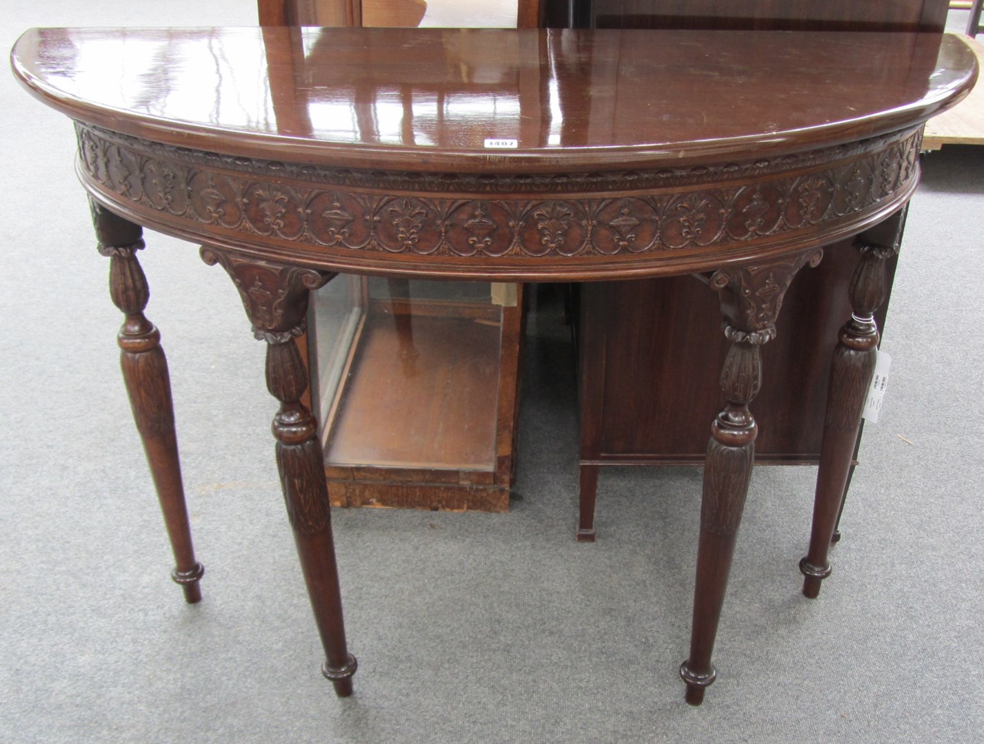 Appraisal: An th century style demi-lune console table with carved frieze