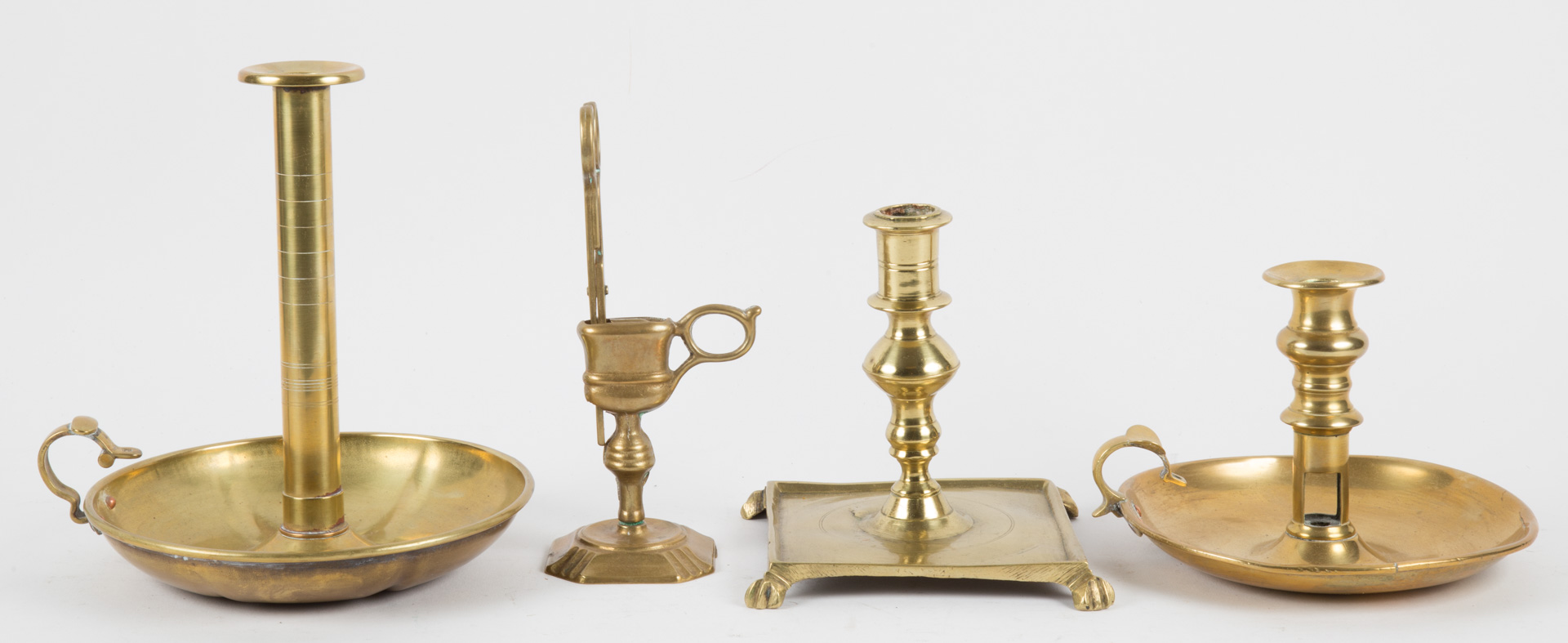 Appraisal: Four brass candlesticks and accessories th th centuries including Spanish