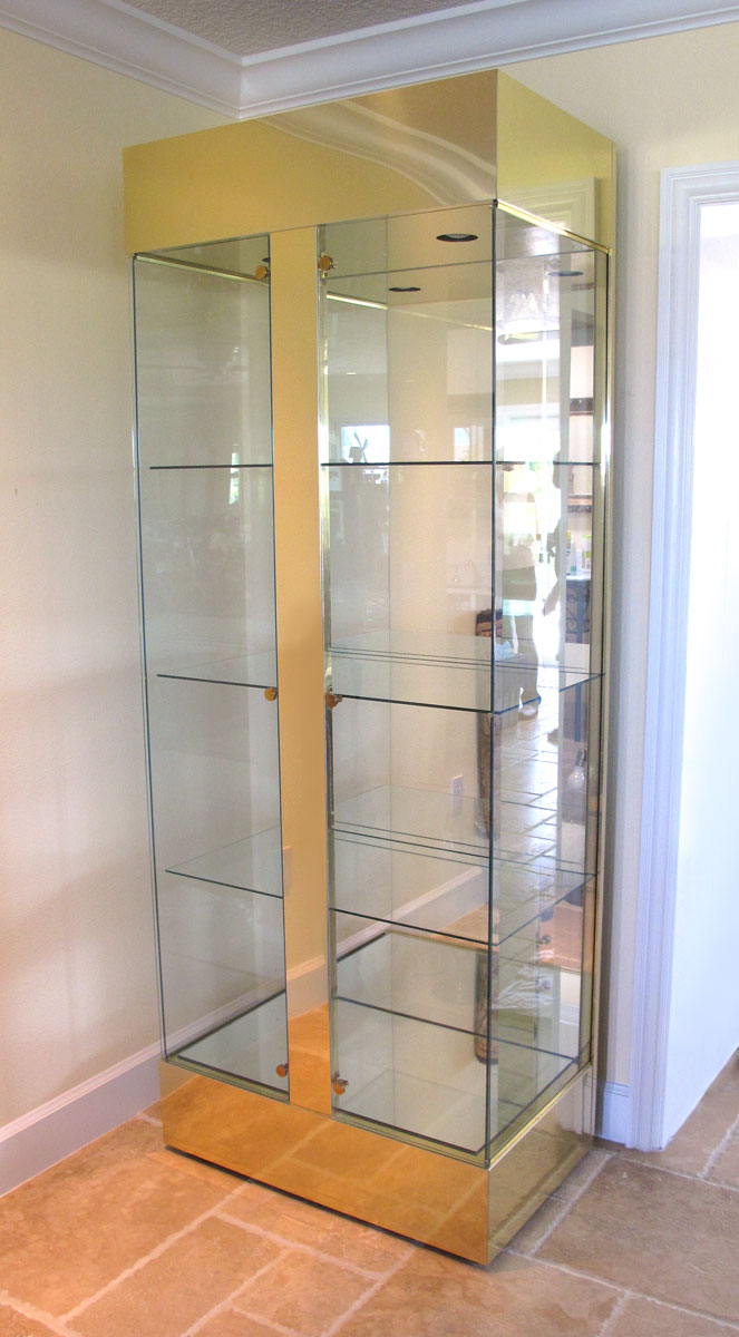 Appraisal: BRASS AND GLASS LIGHTED DISPLAY CASE Illuminated interior mirrored back