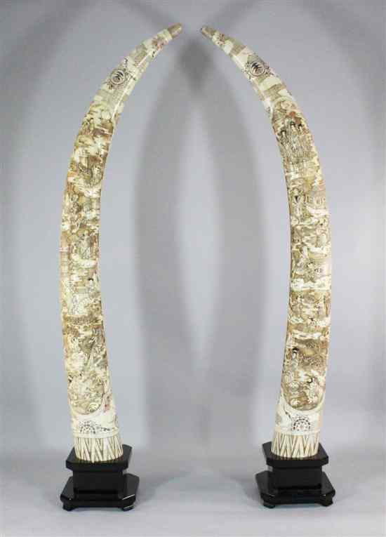 Appraisal: A pair of massive bone veneered tusk ornaments each carved