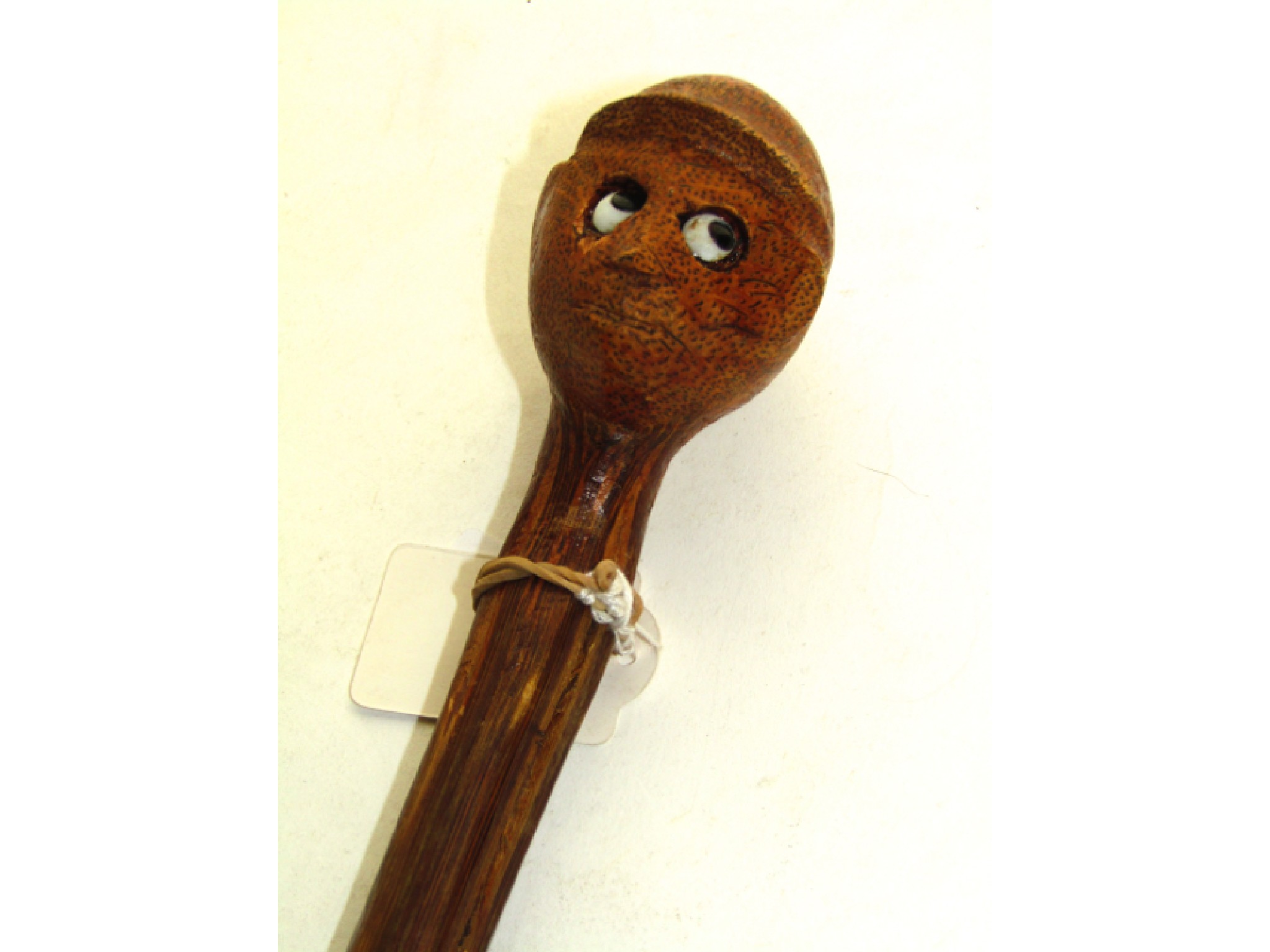 Appraisal: An unusual bamboo walking cane terminating in a carved finial