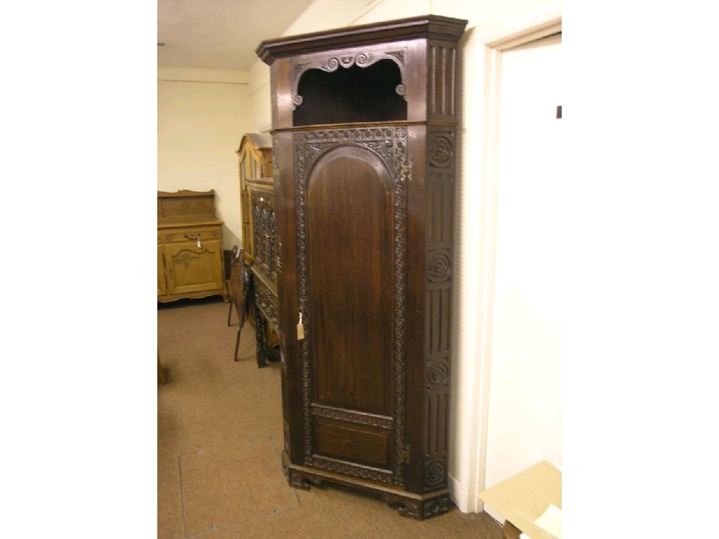 Appraisal: A solid dark oak free-standing corner cupboard uppermost section with