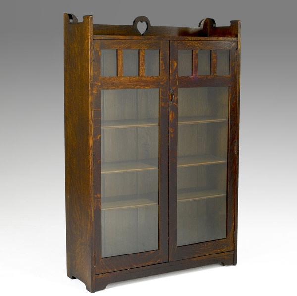 Appraisal: STICKLEY BROTHERSDouble-door bookcase with cut-out and four adjustable shelvesOval paper