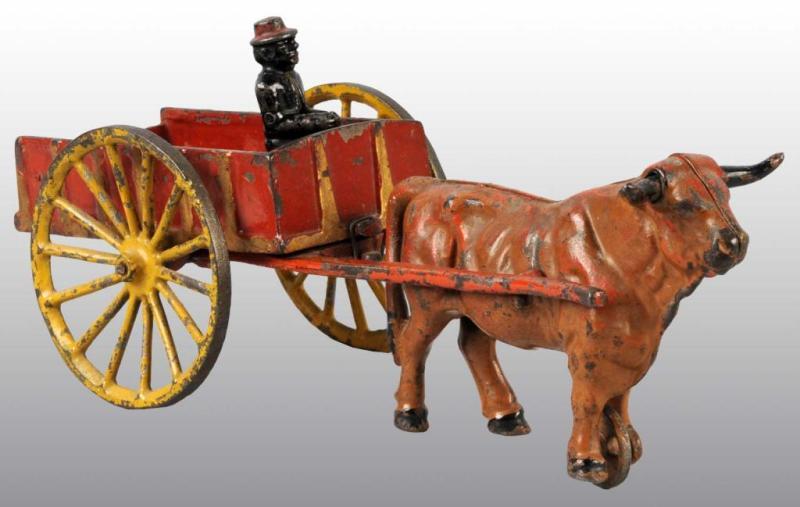 Appraisal: Cast Iron Ox-Drawn Dump Cart Toy Description Red and yellow