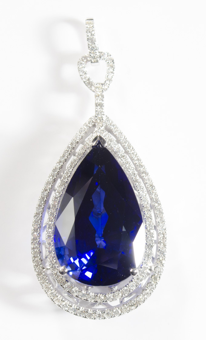 Appraisal: SAPPHIRE AND FOURTEEN KARAT WHITE GOLD PENDANT with round-cut diamonds