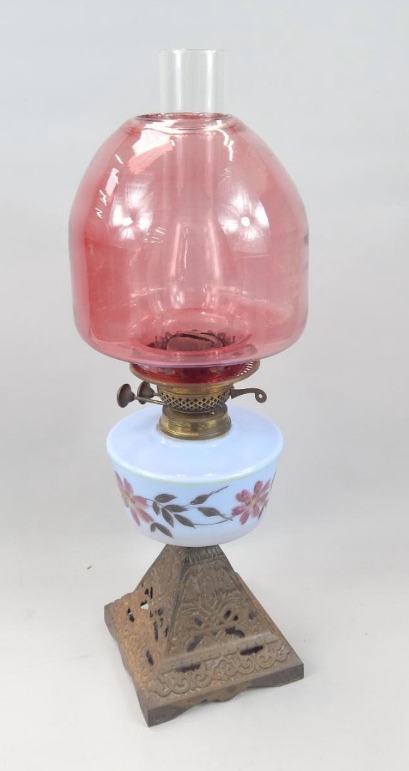 Appraisal: A Victorian oil lamp with a lilac coloured reservoir decorated