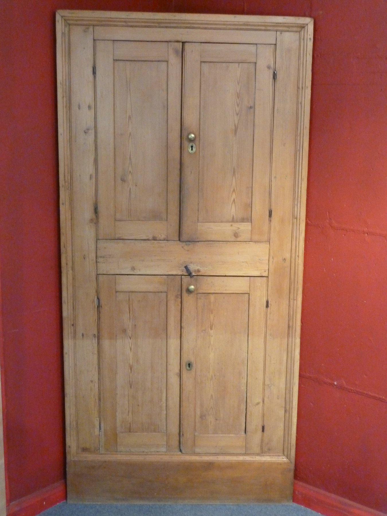 Appraisal: A pine standing corner cupboard the twin panel doors enclosing