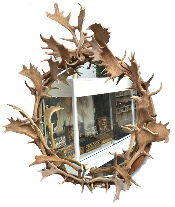 Appraisal: A FALLOW ANTLER MOUNTED WALL MIRROR the bevelled rounded plate