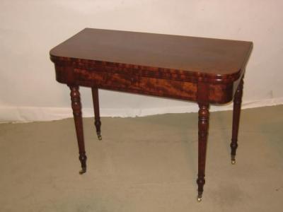 Appraisal: A PLUM PUDDING MAHOGANY TEA TABLE of rounded oblong form