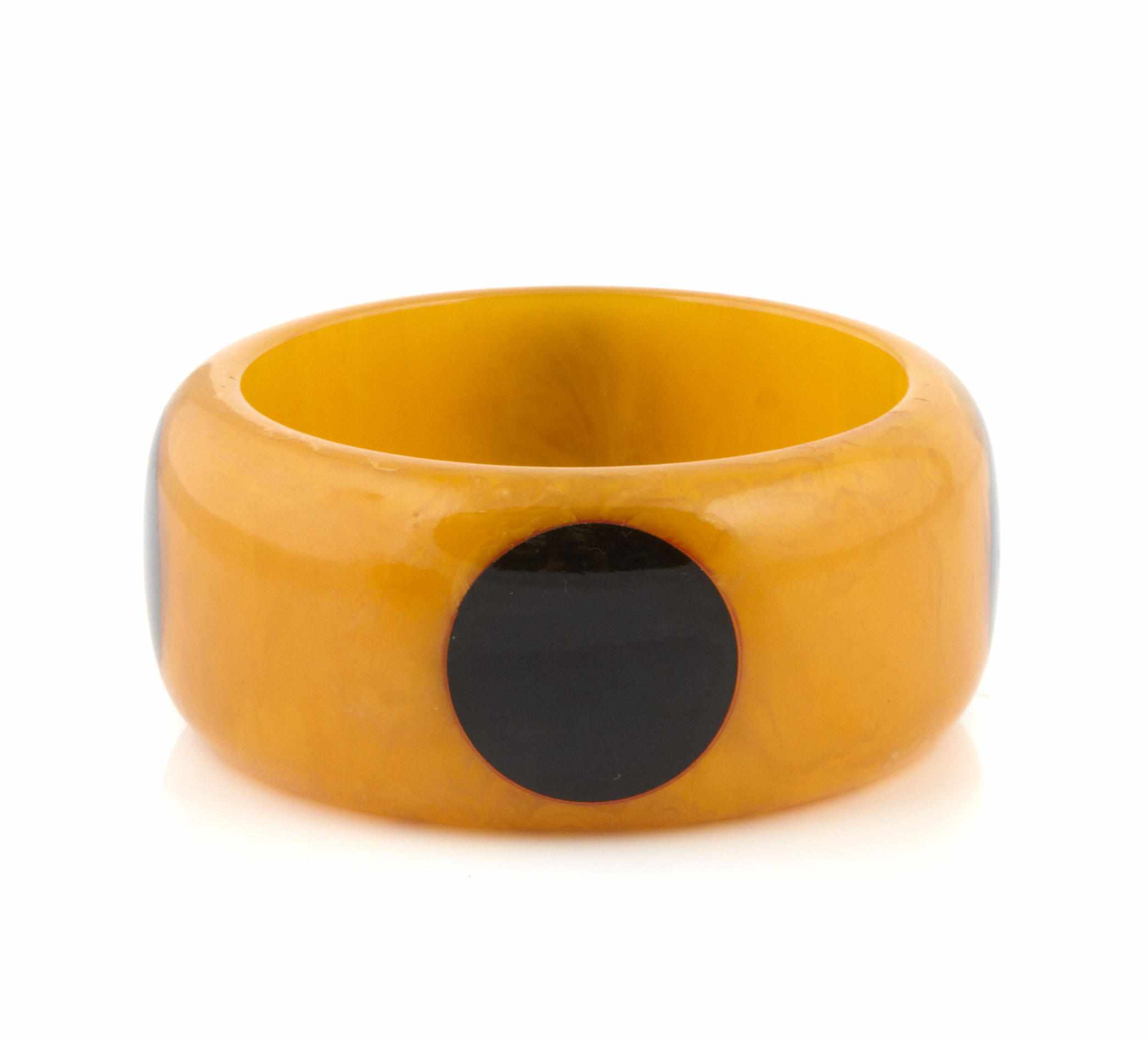 Appraisal: A butterscotch and black Bakelite ''dot'' bangle bracelet