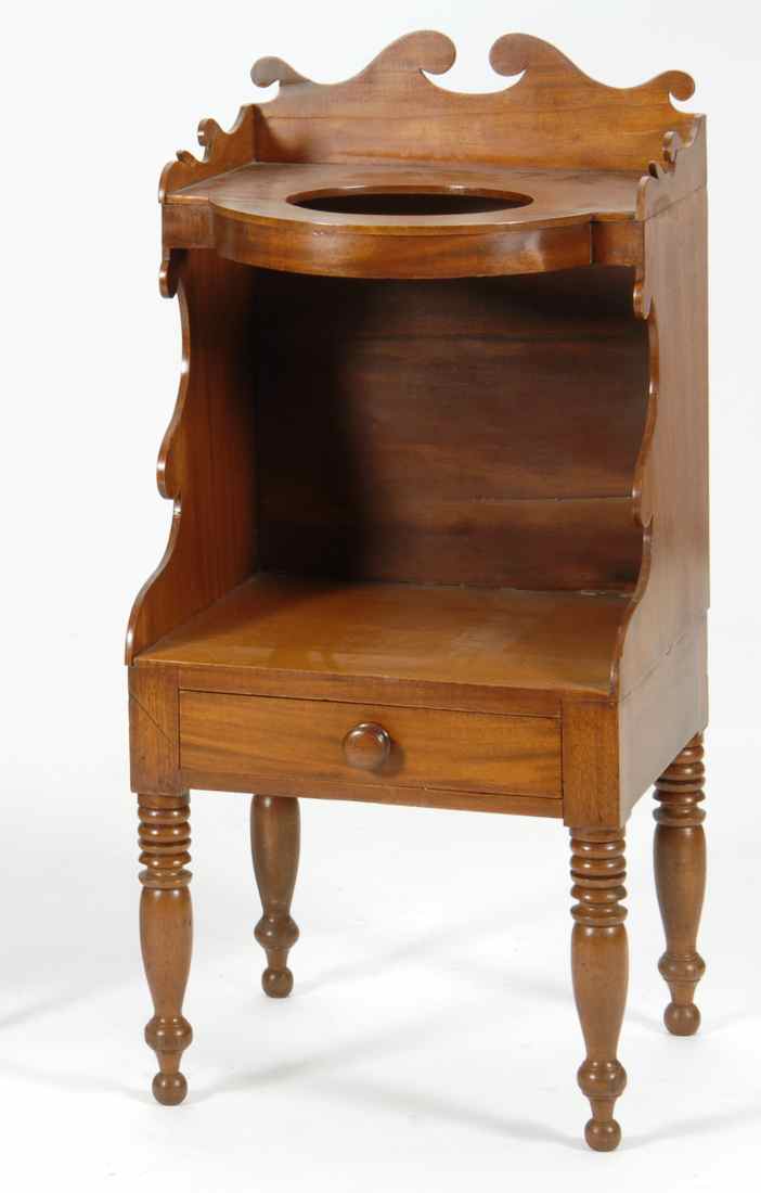 Appraisal: ONE-DRAWER WASHSTAND Early th CenturyIn mahogany with scroll-carved backsplash and