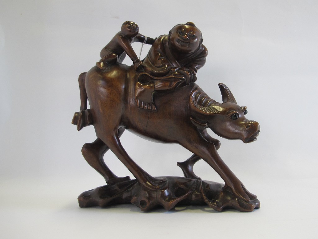 Appraisal: Carved wooden group of a water buffalo and two figures