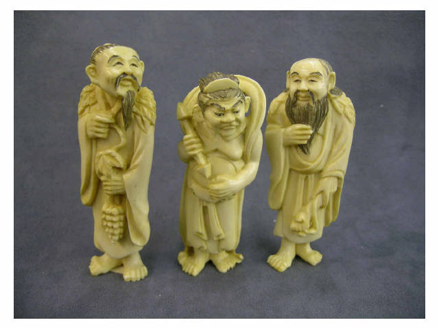 Appraisal: Three tall standing ivory netsuke depicting sage holding a bunch