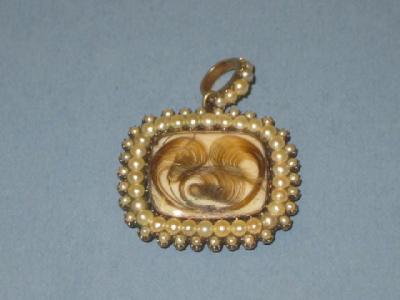 Appraisal: A GEORGIAN SEED PEARL and hairwork pendant of oblong form