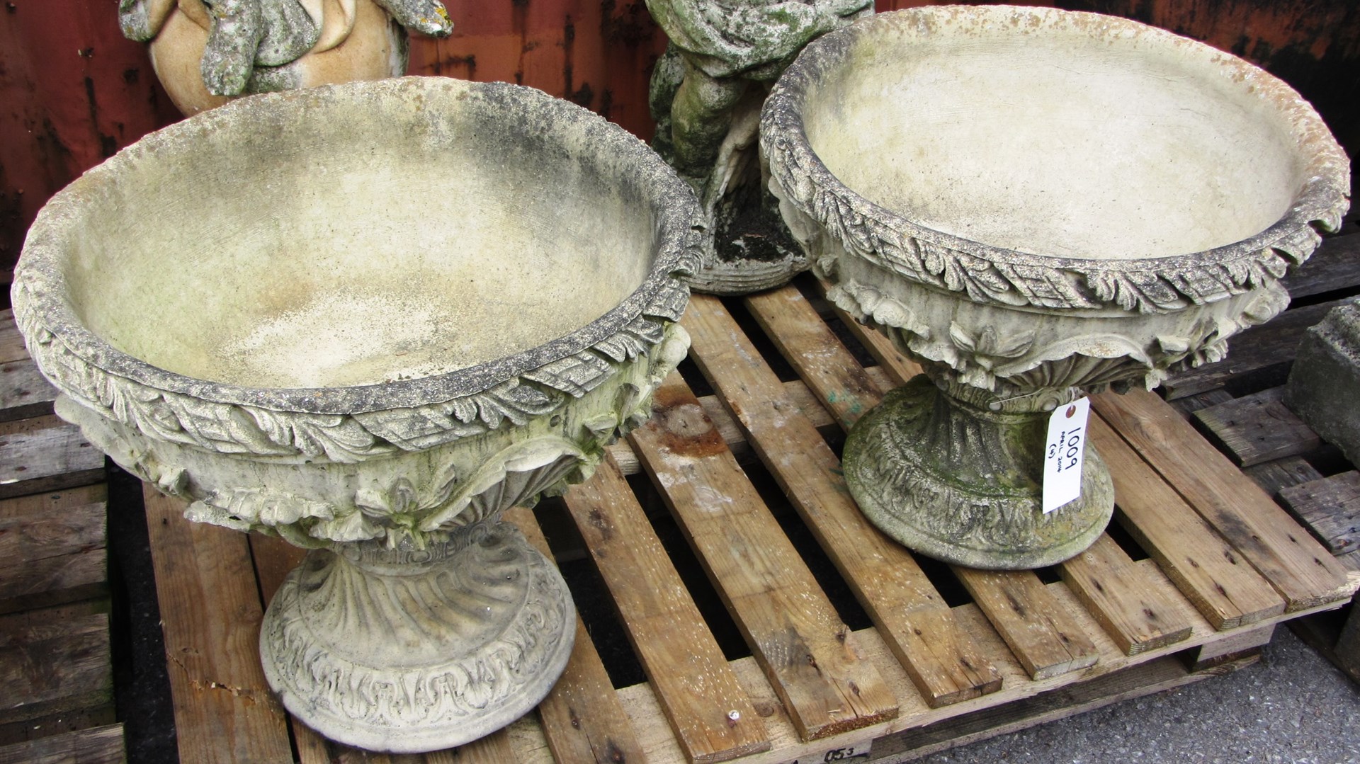 Appraisal: A pair of shallow reconstituted stone urns on spiral fluted