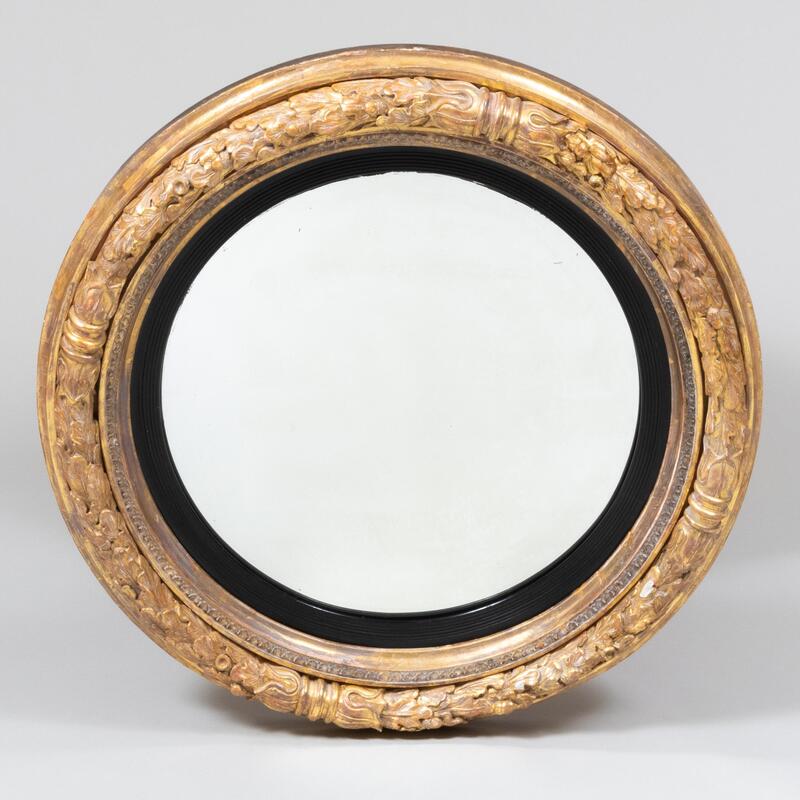 Appraisal: Regency Giltwood and Ebonized Convex Mirror With carved oak leaf