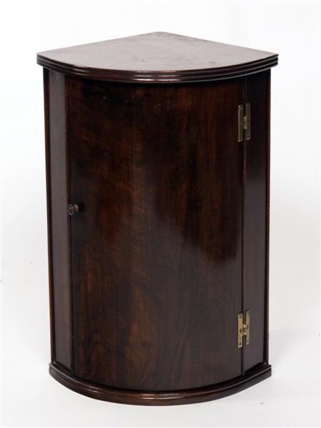 Appraisal: A small mahogany bow front hanging cabinet the reeded top