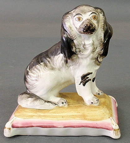 Appraisal: Staffordshire seated black and white spaniel on a cushion base