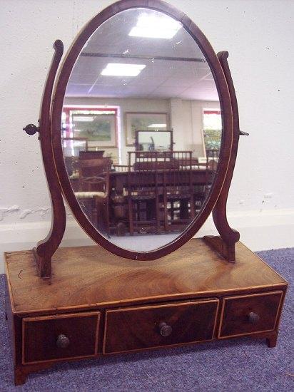 Appraisal: An oval mahogany swing frame toilet mirror the rectangular base