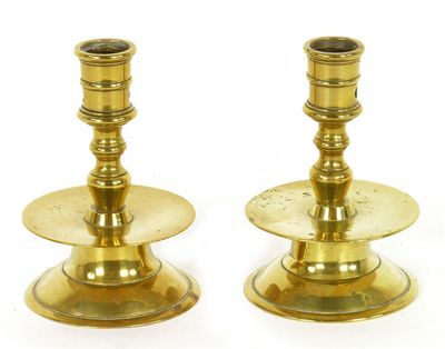 Appraisal: A pair of brass candlesticks with wide drip pans and