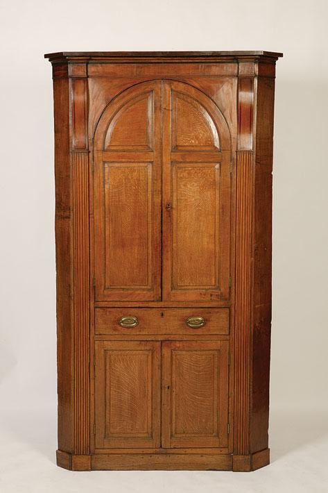 Appraisal: A GEORGE III OAK CORNER CUPBOARD with twin arched panelled