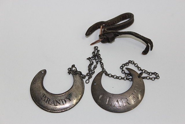 Appraisal: A GEORGIAN WHITE METAL CRESCENT SHAPED CLARET DECANTER LABEL marked