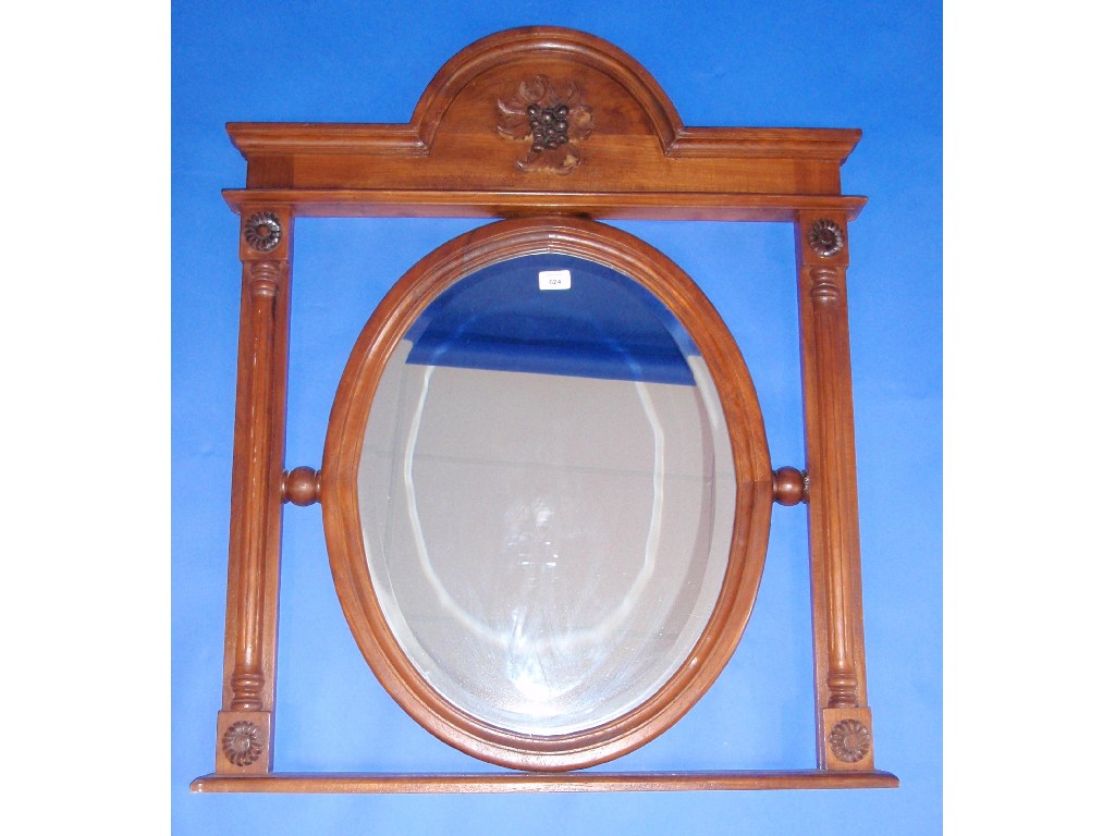 Appraisal: A continental walnut over mantel mirror with bevelled oval plate