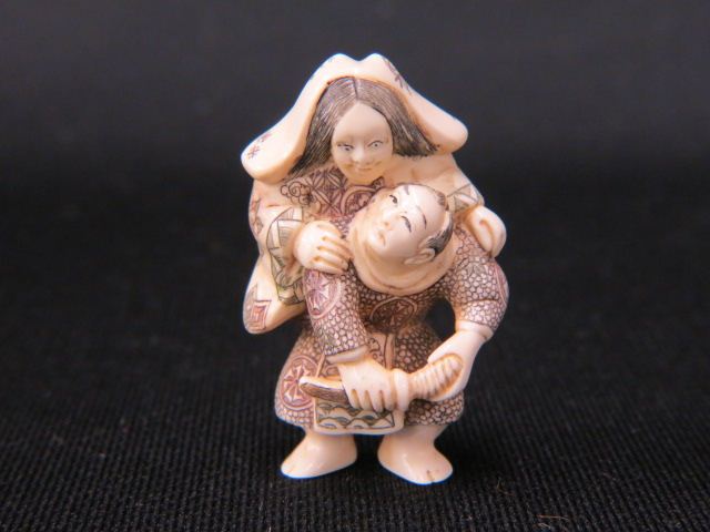 Appraisal: Carved Ivory Netsuke of a Manholding a sword ghost seated