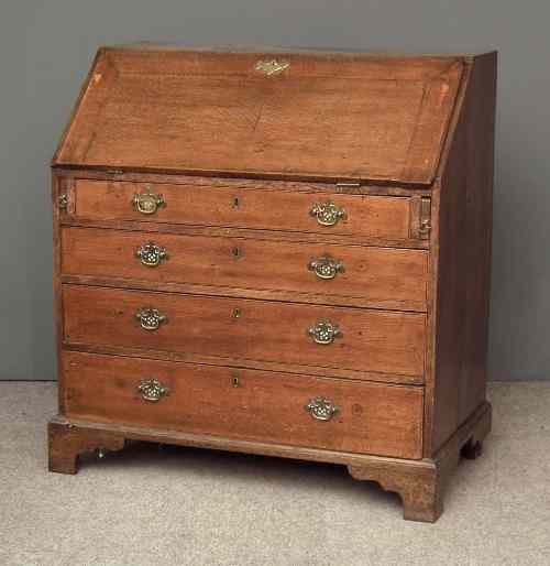 Appraisal: A George III oak bureau the slope enclosing pigeon-holes three