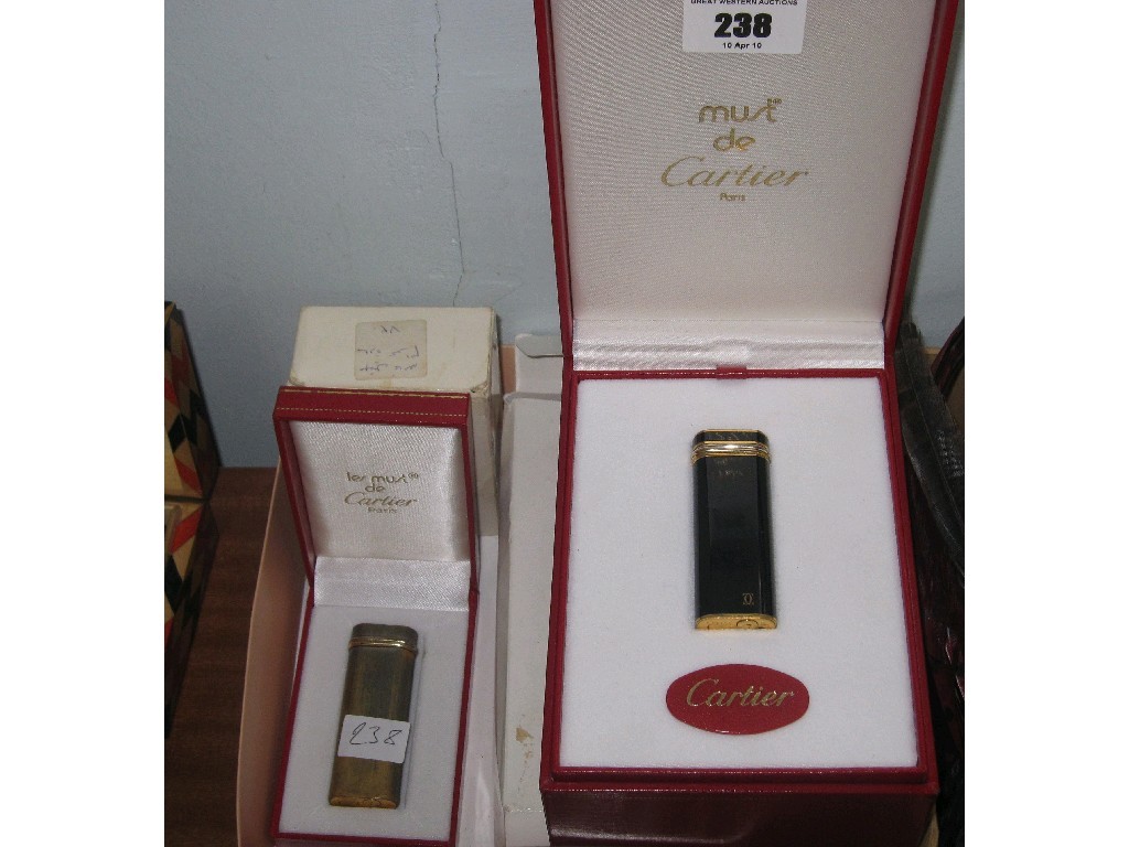 Appraisal: Lot comprising two Cartier cigarette lighters in their boxes