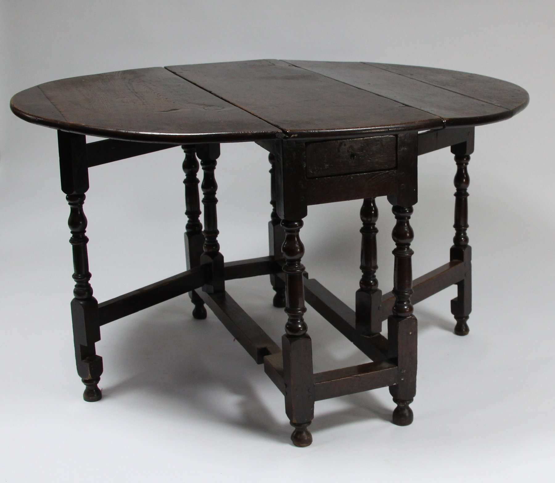 Appraisal: An oak oval two-flap gate-leg table on baluster turned legs