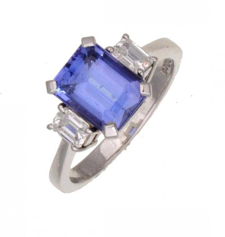 Appraisal: A SAPPHIRE AND DIAMOND RING the step cut sapphire flanked