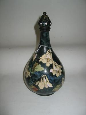 Appraisal: A DOULTON FAIENCE LIDDED VASE of bottle form painted with