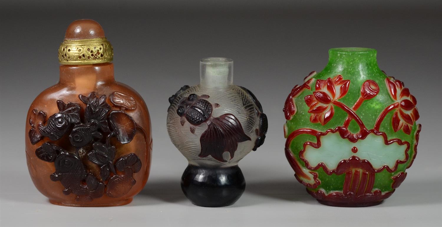 Appraisal: Carved Peking glass color Chinese snuff bottles with fish decoration