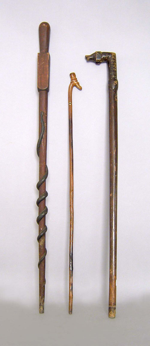 Appraisal: Three carved walking sticks one with hounds head grip