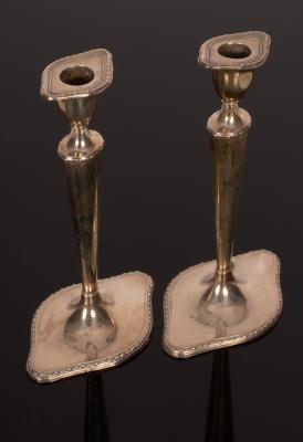 Appraisal: A pair of Edwardian silver candlesticks London tapered knopped stems