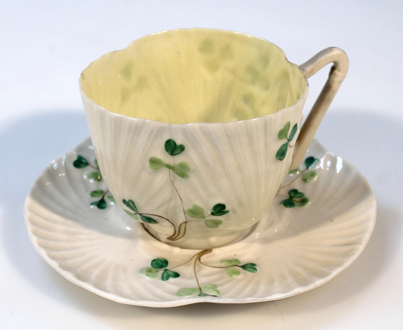 Appraisal: A thC Belleek cup and saucer the shaped textured body