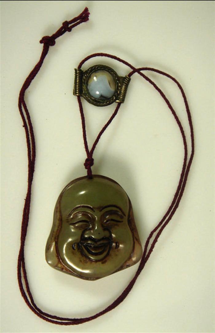 Appraisal: Carved jade hotai face pendant on cord silver slide h