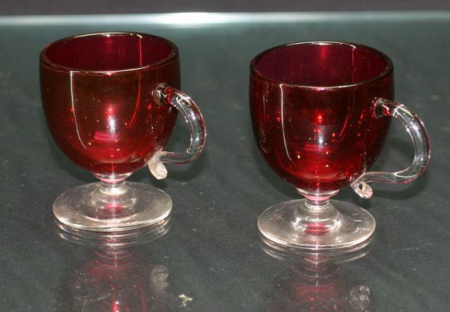 Appraisal: Two Victorian ruby glass custard cups with Mary Gregory style