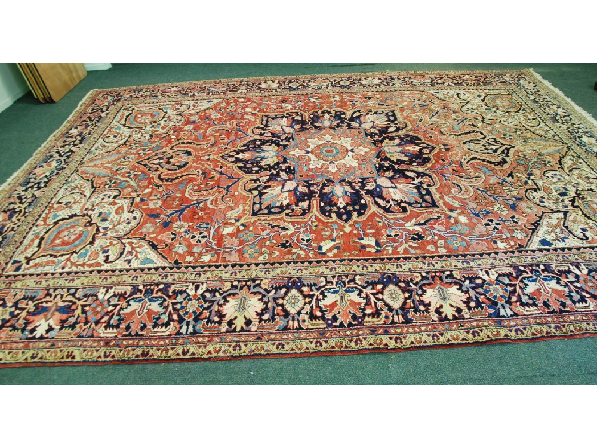 Appraisal: HERIZ PERSIAN CARPET with midnight blue large centre petal shaped