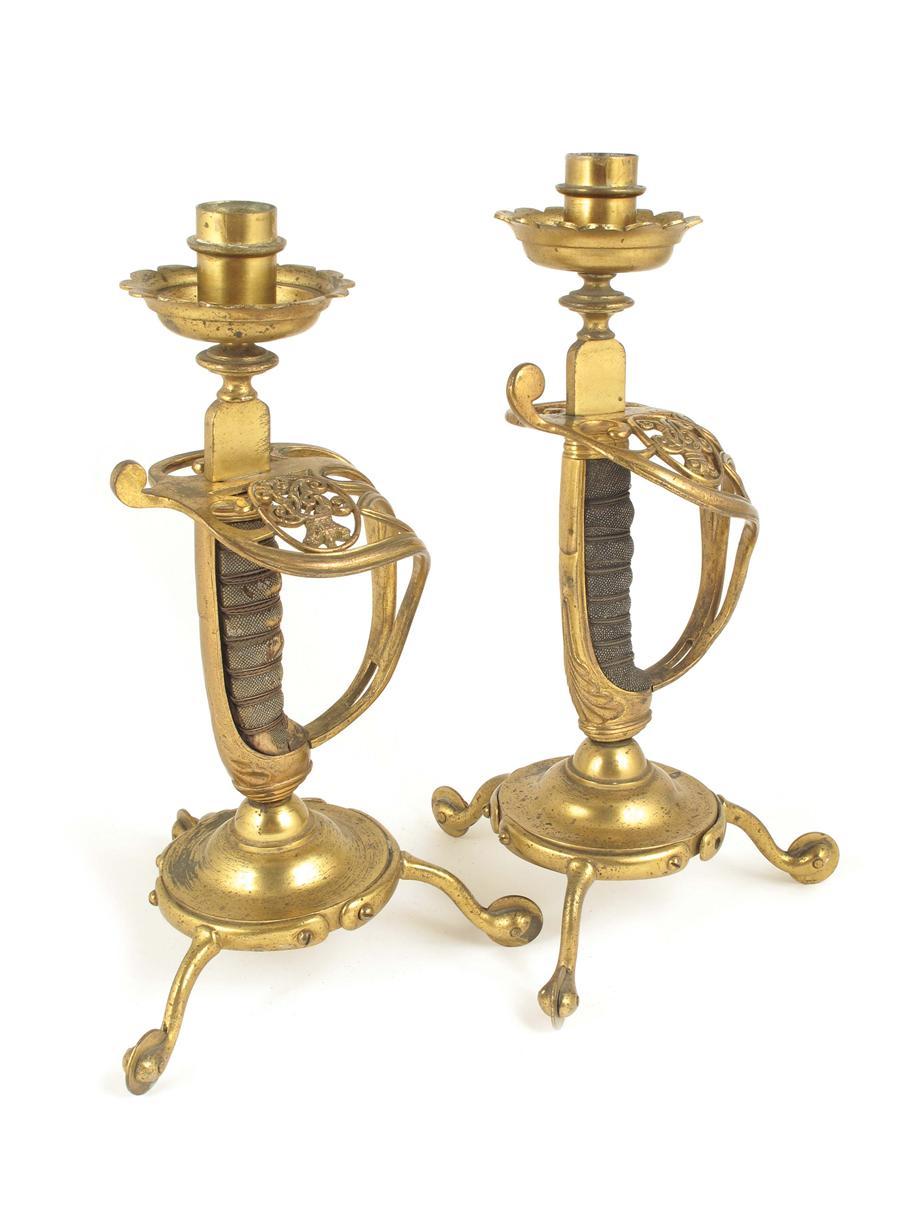 Appraisal: A pair brass sword hilt and spur novelty candlesticks by