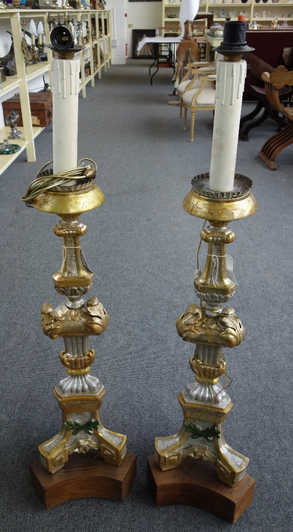 Appraisal: A pair of Italian silvered and giltwood altar candlesticks probably