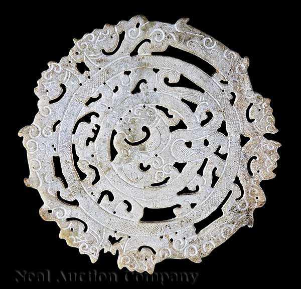 Appraisal: A Chinese Reticulated and Incised White Jade Dragon Disc Warring