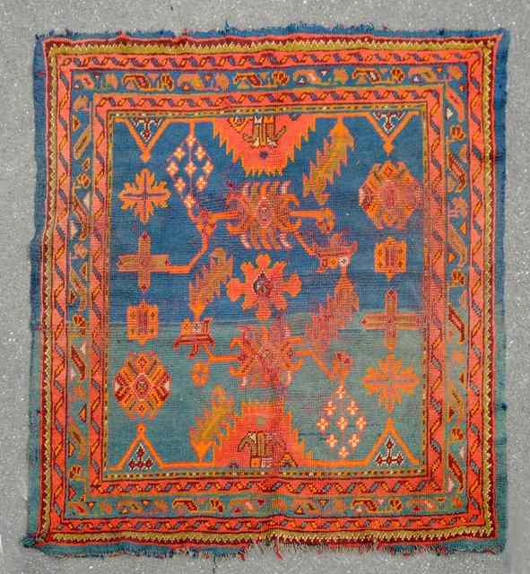 Appraisal: A TURKEY BLUE GROUND RUG with stylised foliate decoration and