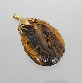 Appraisal: A Carved Tiger Eye Pendant with k Gold Bail A