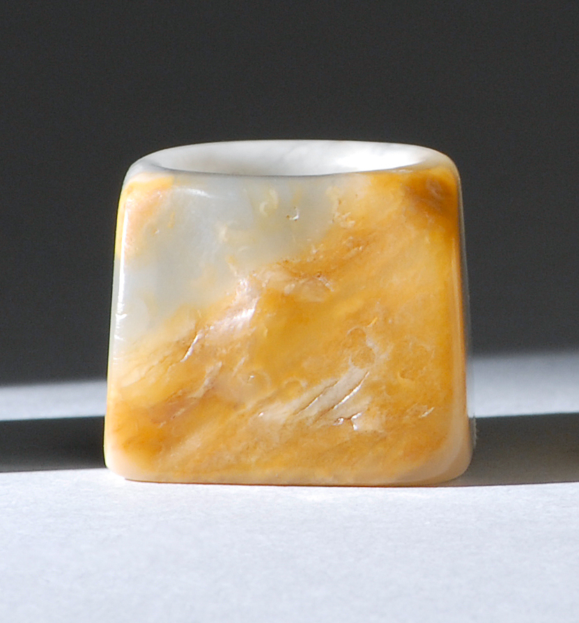 Appraisal: GRAY WHITE AND RUSSET JADE ARCHER'S RING th CenturyWith a