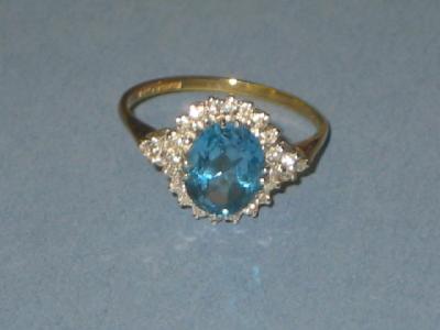 Appraisal: A BLUE TOPAZ AND DIAMOND CLUSTER RING the central oval