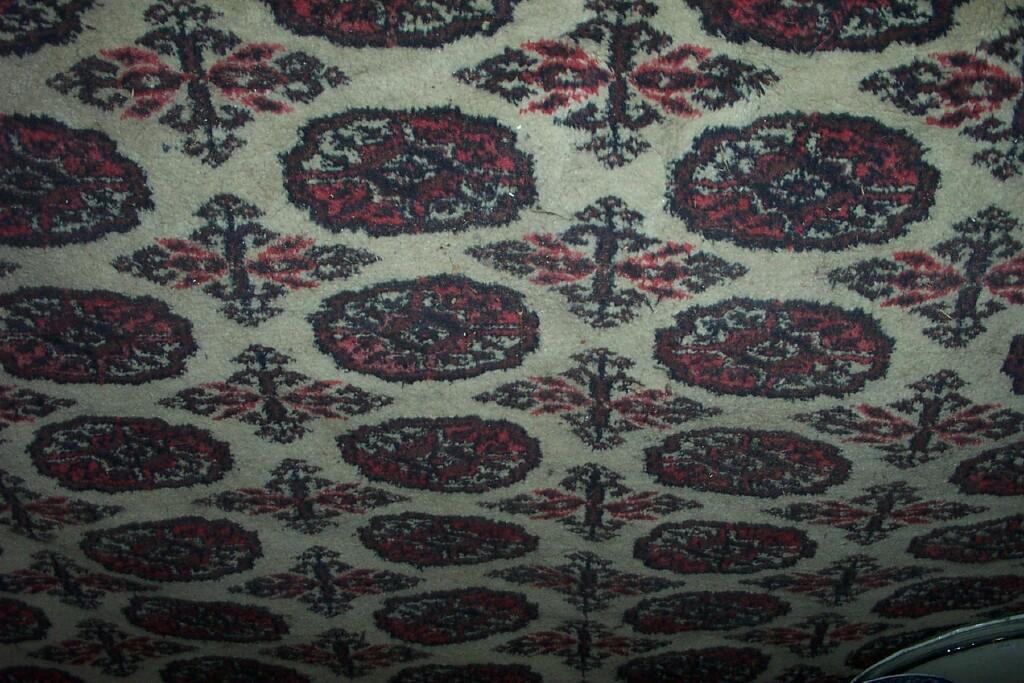 Appraisal: A cream ground wool carpet with repeating gul motifs in