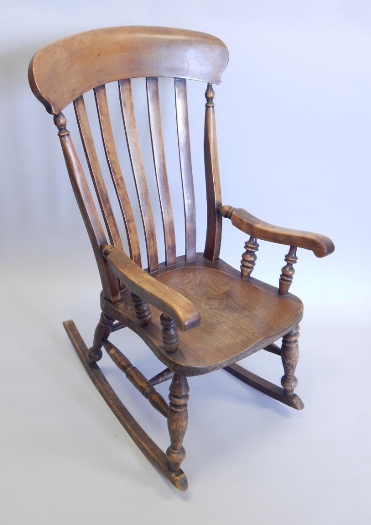 Appraisal: A thC Windsor type rocking chair with a slatted back