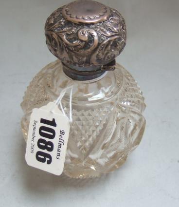 Appraisal: A silver hinge lidded faceted spherical glass scent bottle with